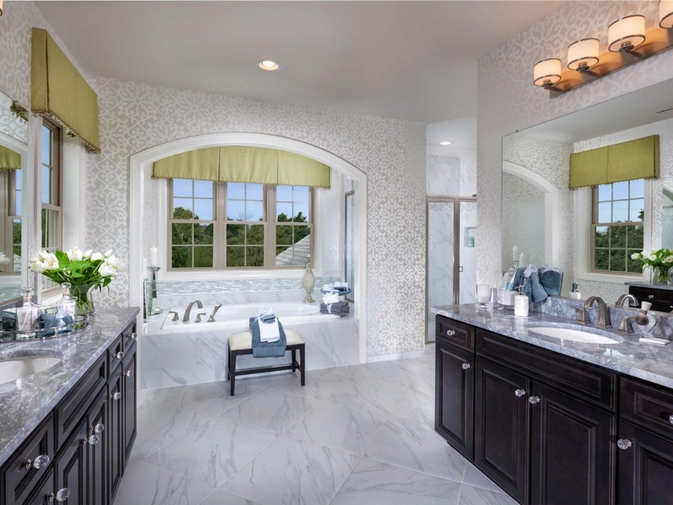 Winchester-Walnut-Creek-bathroom Luxurious bathroom with dual vanities, marble flooring and bathtub under arched window.